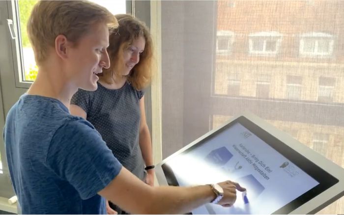 Zwei Personen vor einem Touch-Terminal